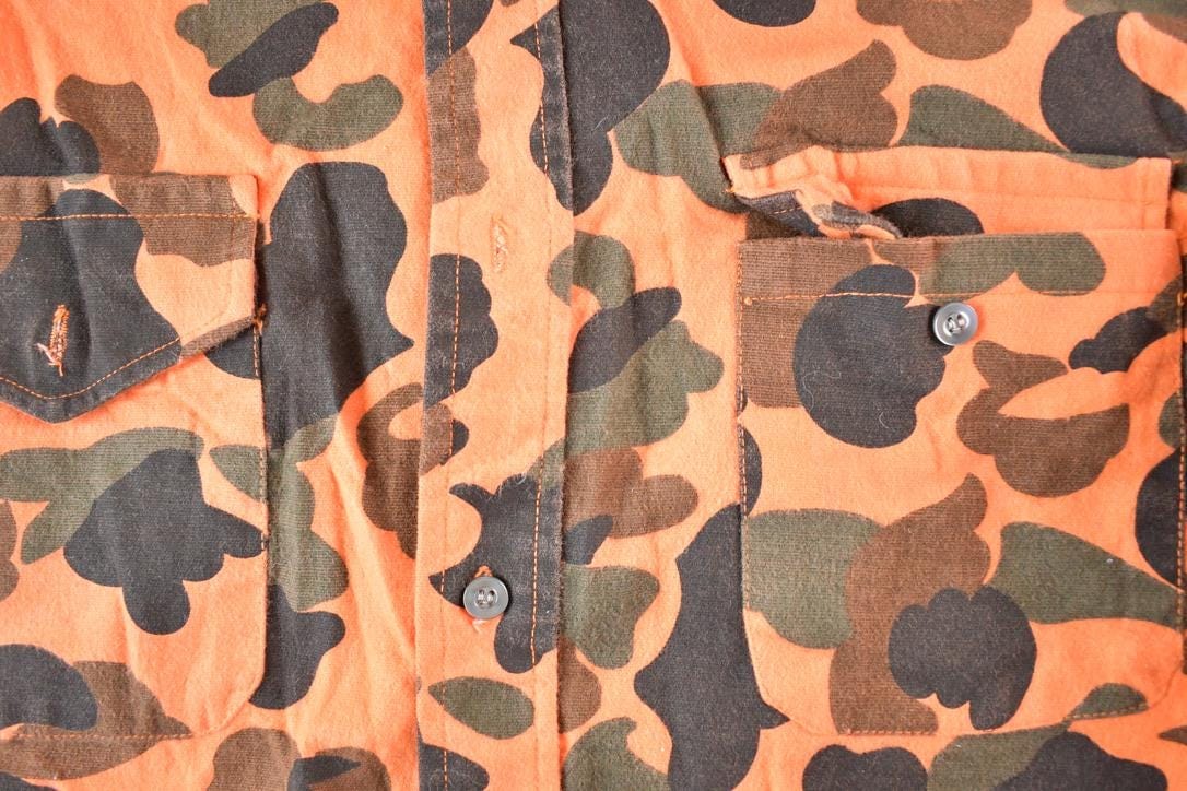 Vintage 1970s The Woodsman Orange Camo Button Up Shirt Mens L from propervintagecanada