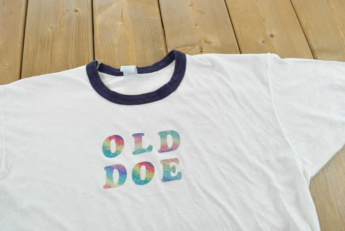 Vintage 1980s Old Doe Rainbow Iron On Print Ringer T-Shirt Men's M from propervintagecanada