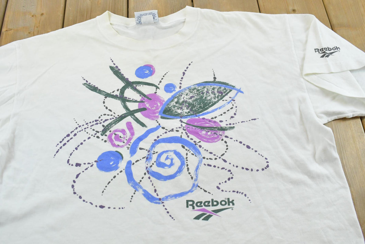 Vintage 1990s Abstract Reebok Promotional T-Shirt Men's Cropped XL from propervintagecanada