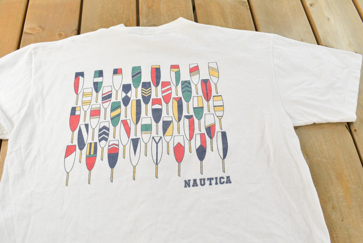 Vintage 1990s Nautica Rowing Oars Graphic T Shirt Men's L from propervintagecanada