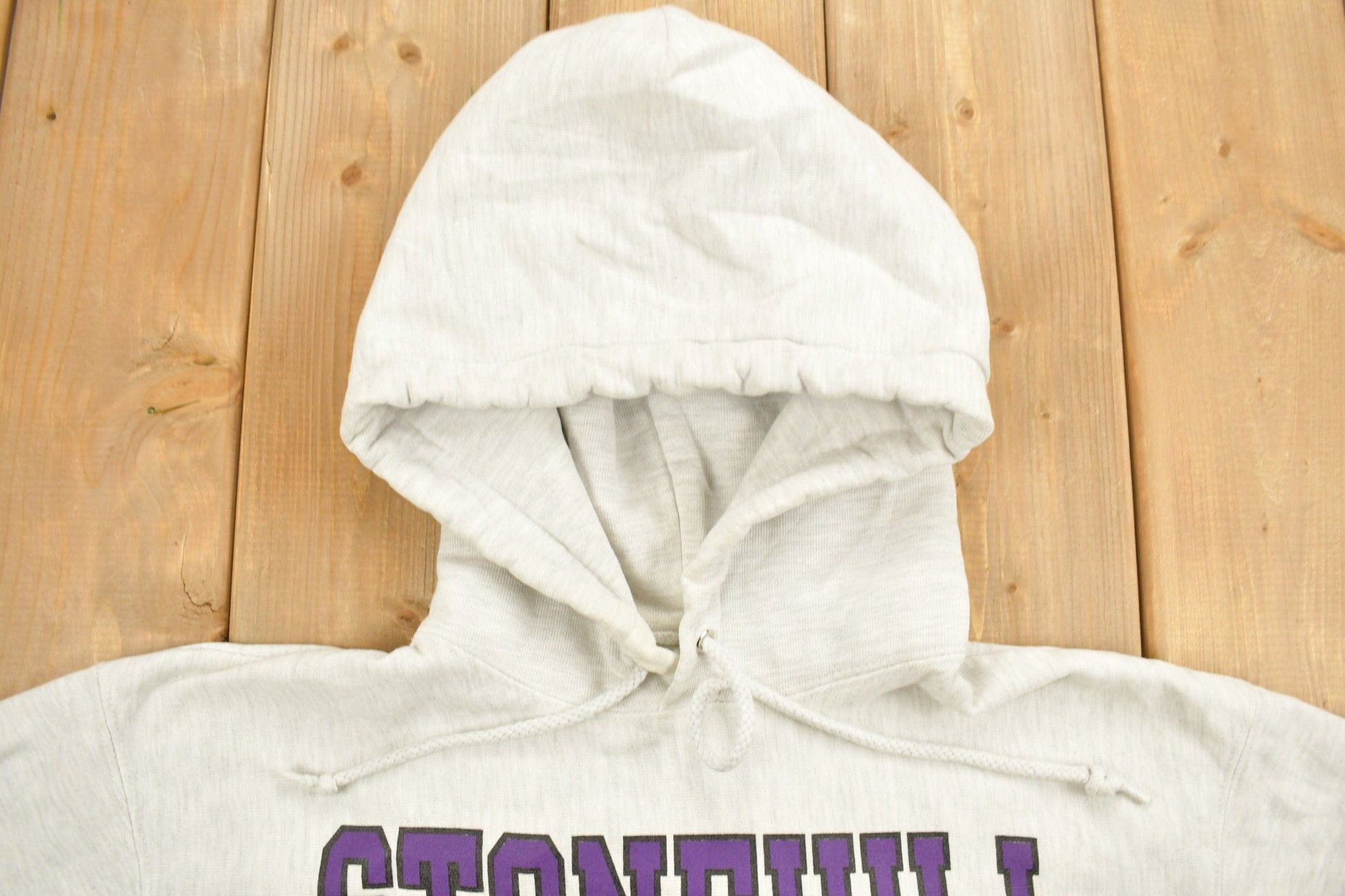 Vintage 1990s Stonehill University Collegiate Champion Reverse Weave Hoodie Men's Medium from propervintagecanada