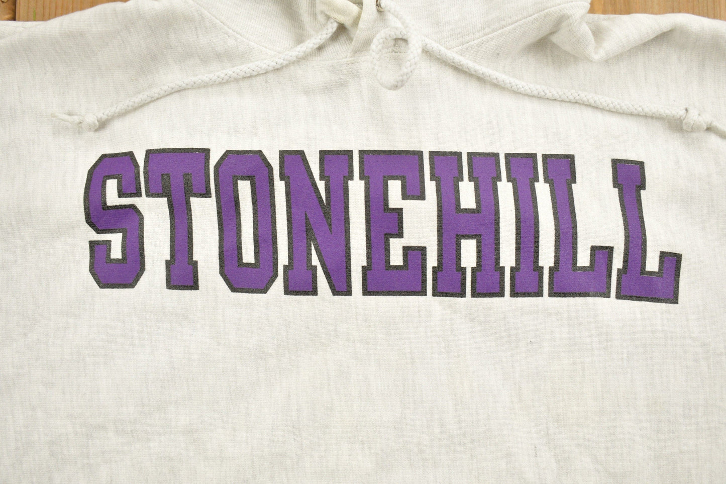Vintage 1990s Stonehill University Collegiate Champion Reverse Weave Hoodie Men's Medium from propervintagecanada