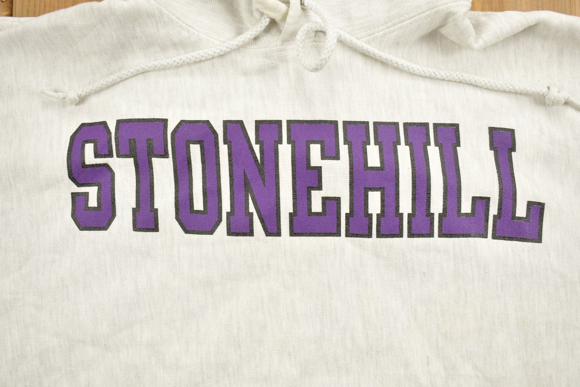 Vintage 1990s Stonehill University Collegiate Champion Reverse Weave Hoodie Men's Medium from propervintagecanada