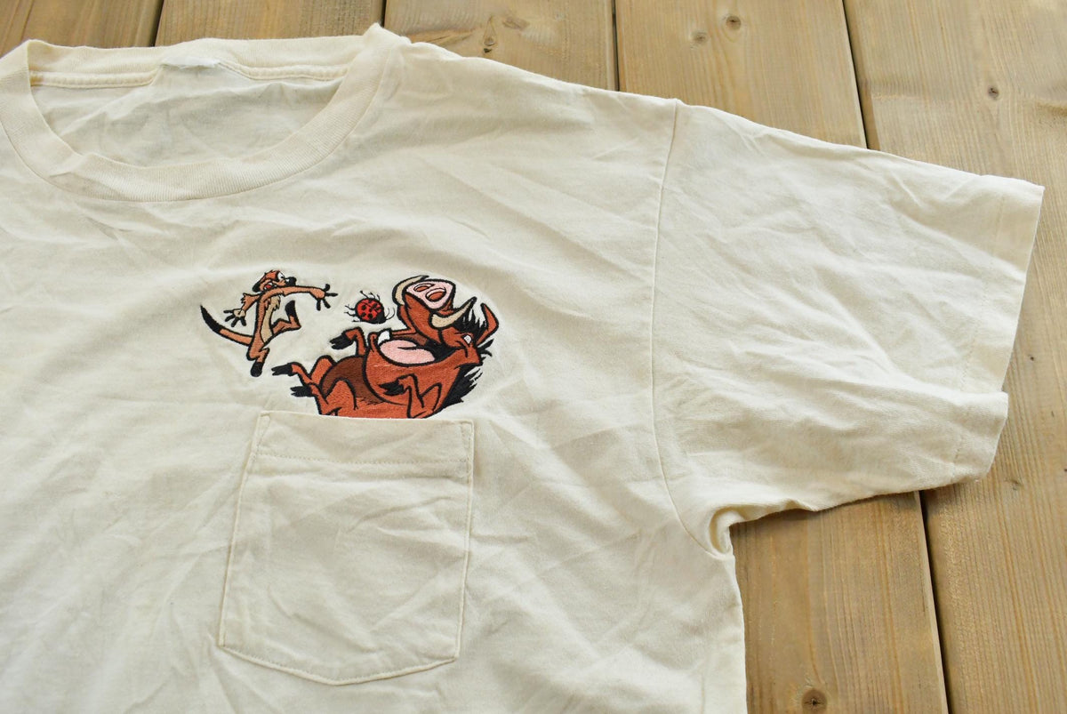 Vintage 1990s The Lion King Timon and Pumba Embroidered Disney Cartoon Promo Pocket T-Shirt Mens L from propervintagecanada