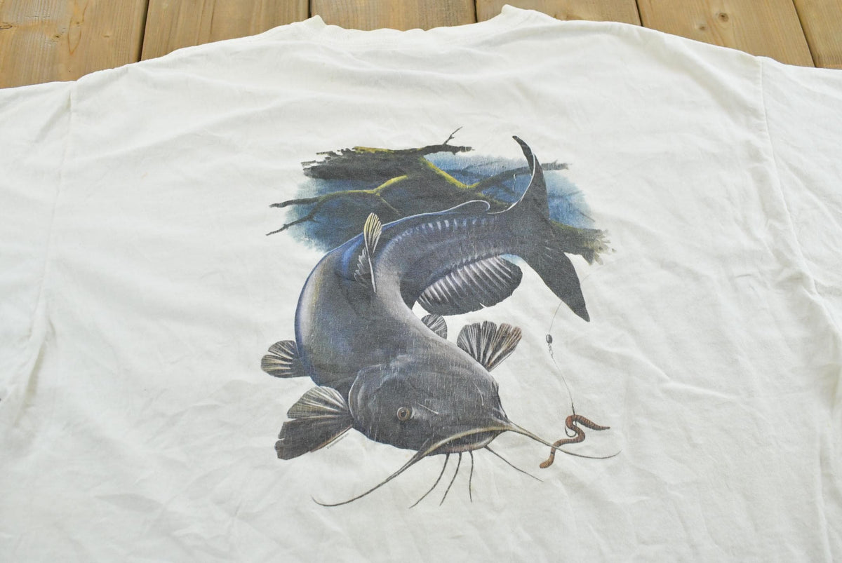 Vintage 2000s Bite Me Fishwear Catfish Promotional Souvenir Pocket T-Shirt Men's XL from propervintagecanada